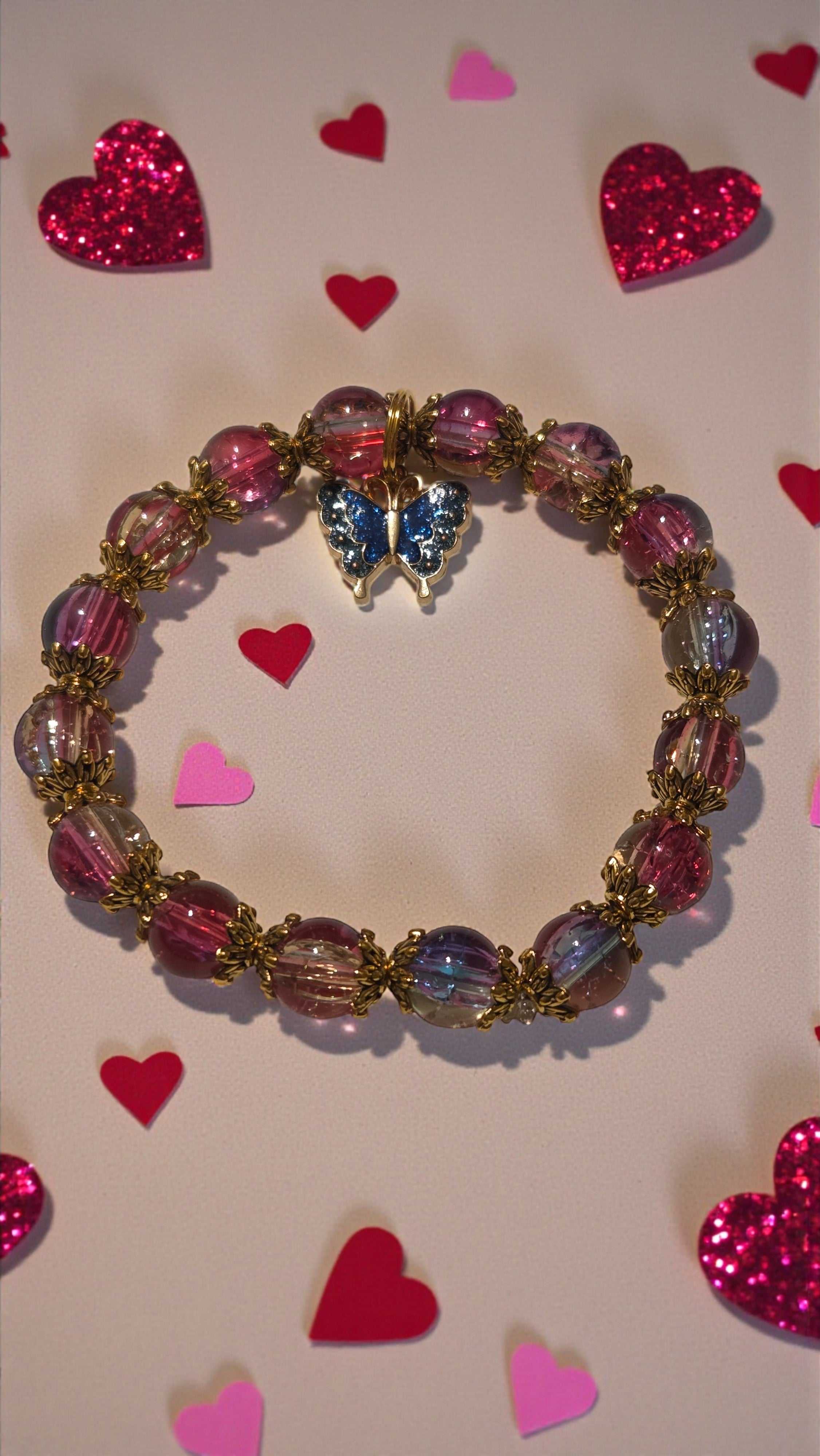 Butterfly charm bracelet with blue and pink crackle beads and gold tone enamel charm on stretchy cord