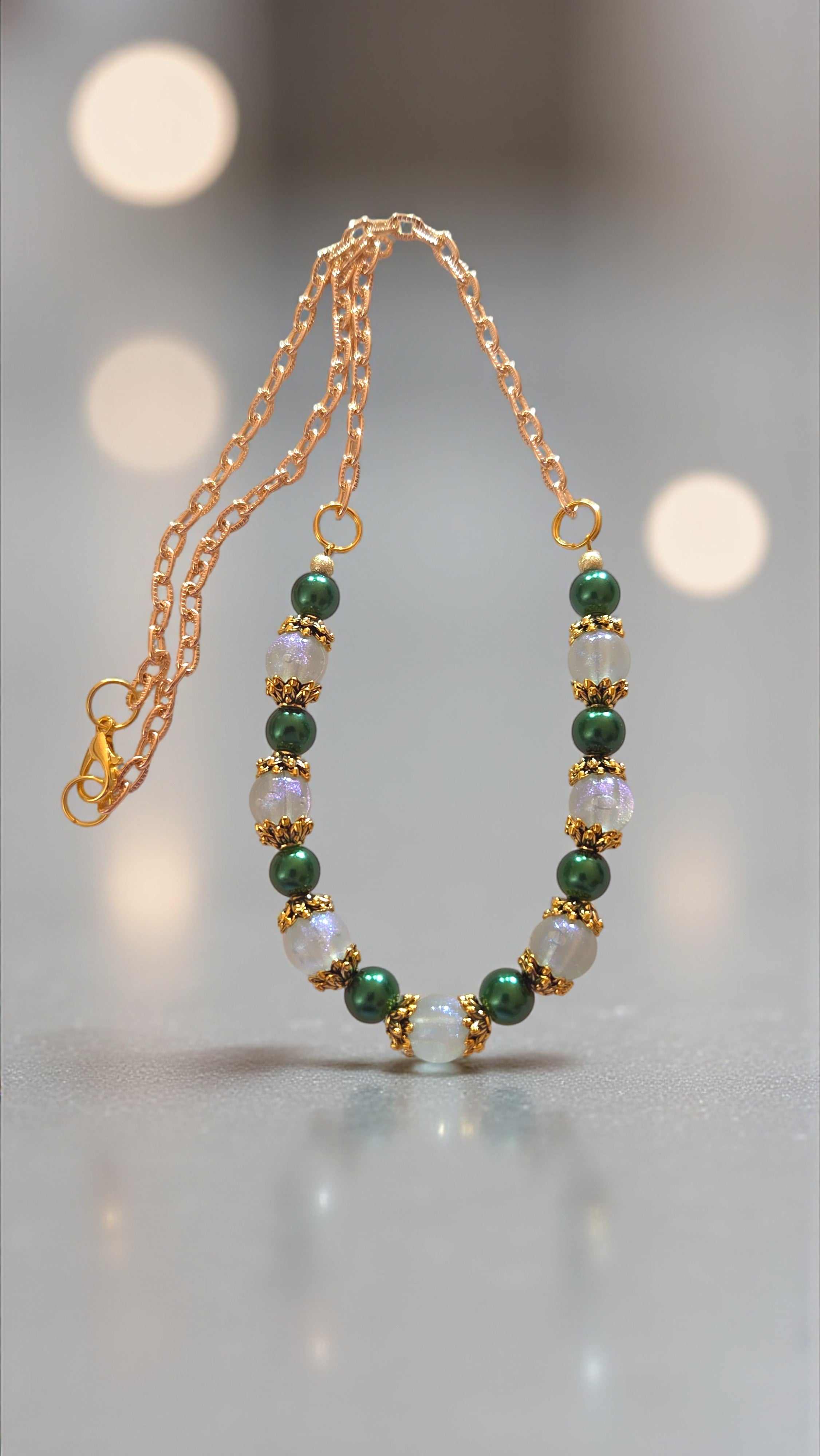 Green bead necklace with acrylic glitter beads, glass pearl beads, gold bead caps, and gold chain